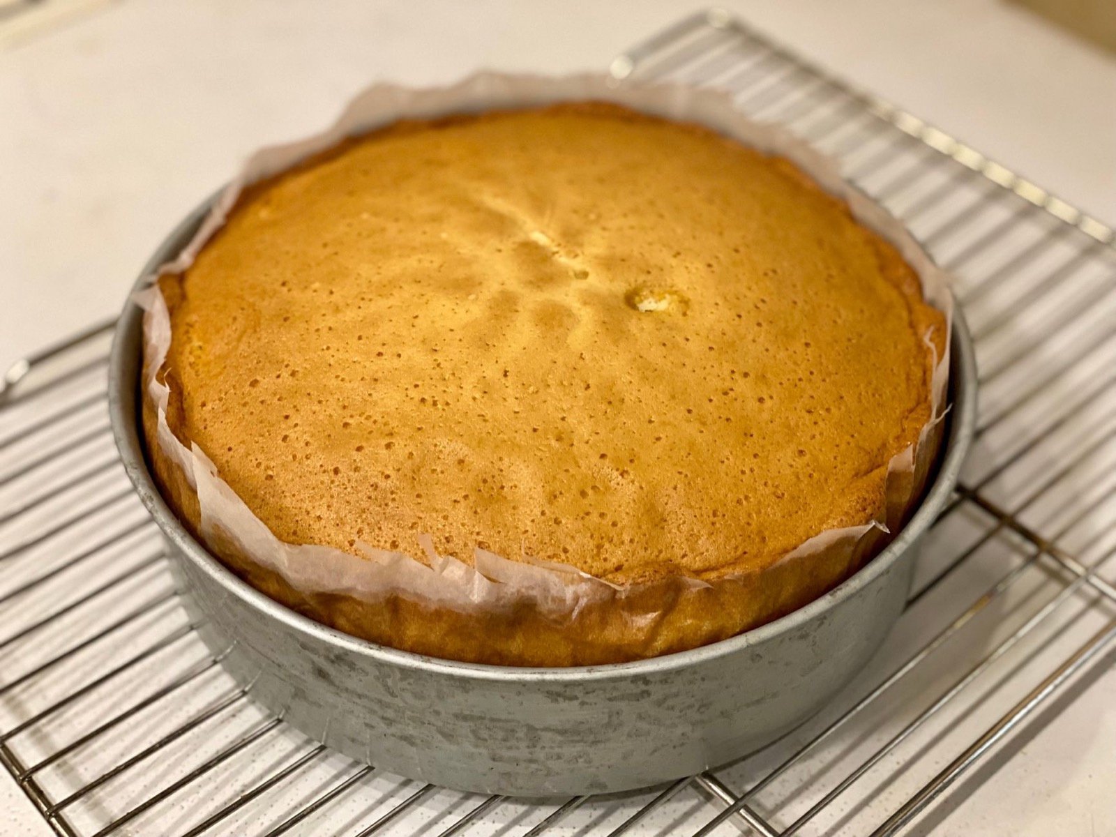 Homemade sponge cake cooling on a wire rack