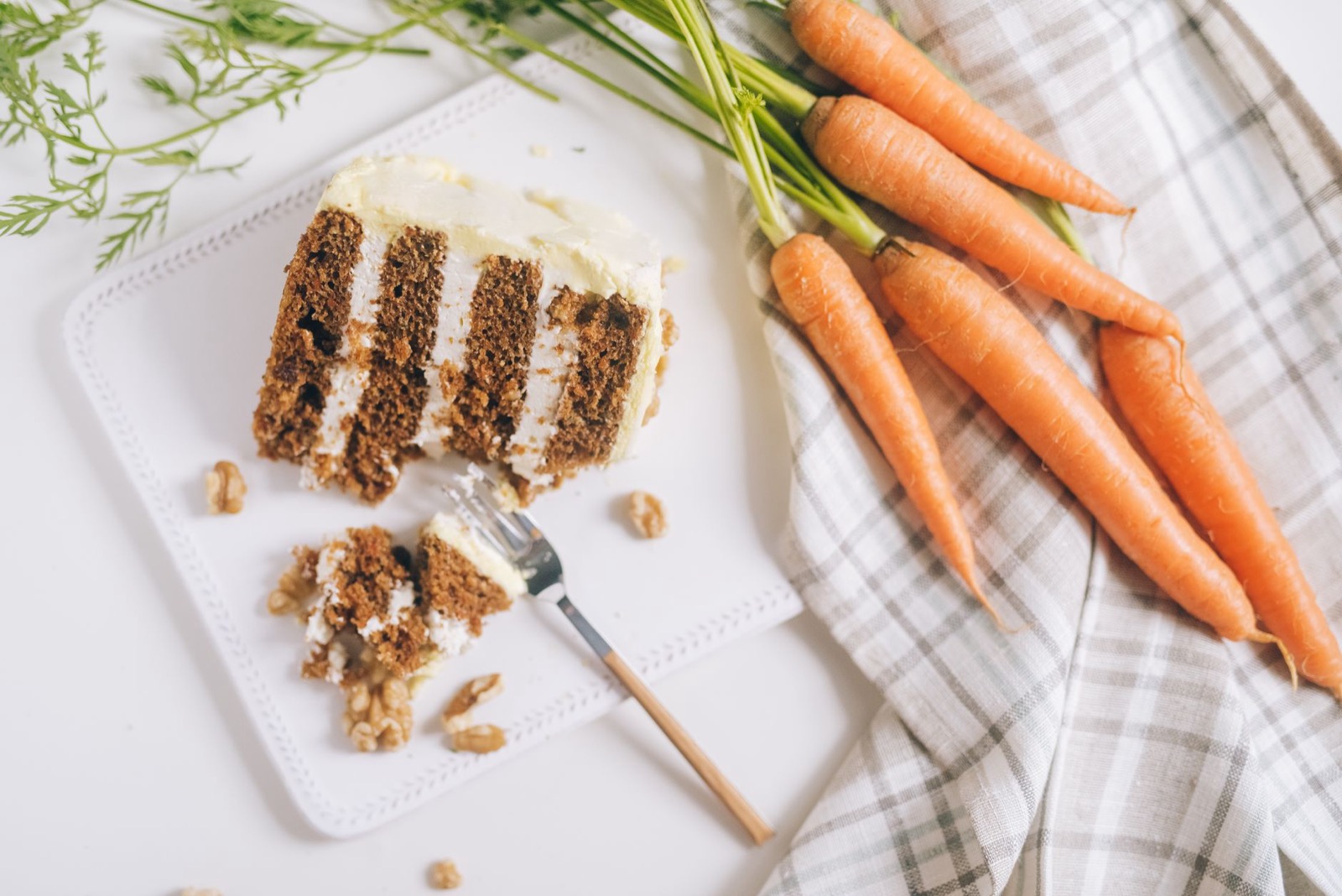 Slice of carrot cake with frosting and walnuts